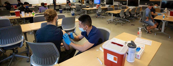 Medical student giving a COVID vaccination.