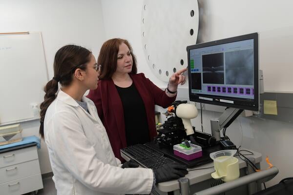 Dr. Tiwari-Woodruff at a lab computer with a student