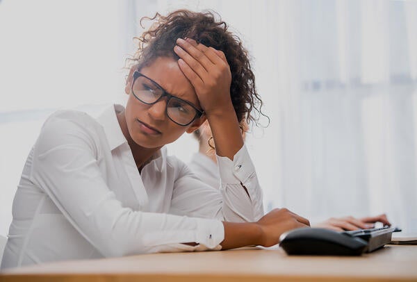 student looking stressed while sitting at a desk - photo courtesy of DepositPhotos.com