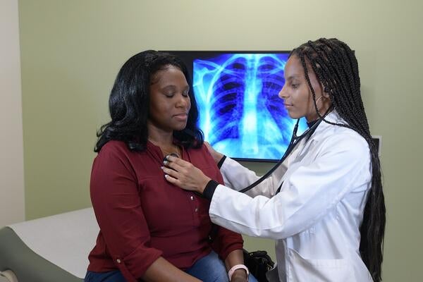 Medical student checking the heart of a patient