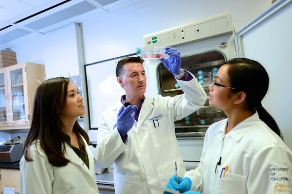 Declan McCole in the lab with two graduate students