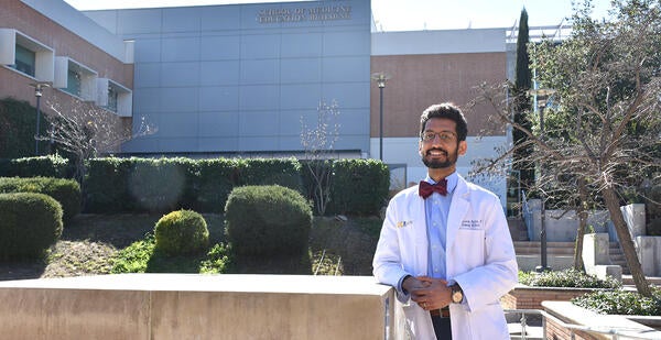 Moazzum Bajwa in front of the SOM Education Building