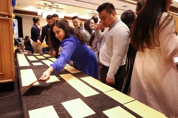 Students retrieving their envelopes from the table