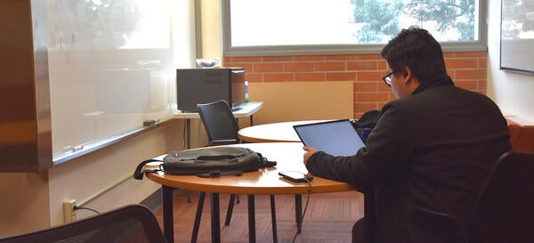A UCR Medical Student uses his laptop in a student lounge.