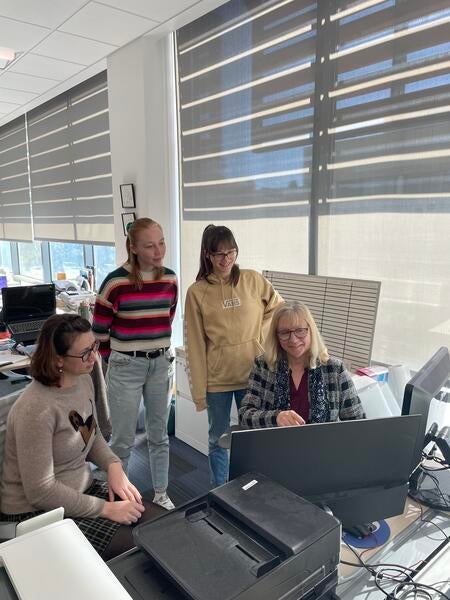 Dr. Iryna Ethell sitting at a computer surrounded by students