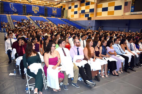 Class of 2028 sitting in the gym at their white coat ceremony