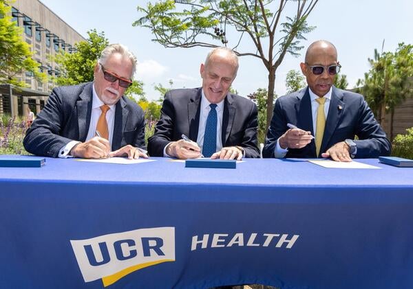 Garry Spanner, president of Canyon Springs Marketplace Corp, UCR Chancellor Kim Wilcox, and UC President Michael V. Drake sign a letter of intent. Photo by Stan Lim