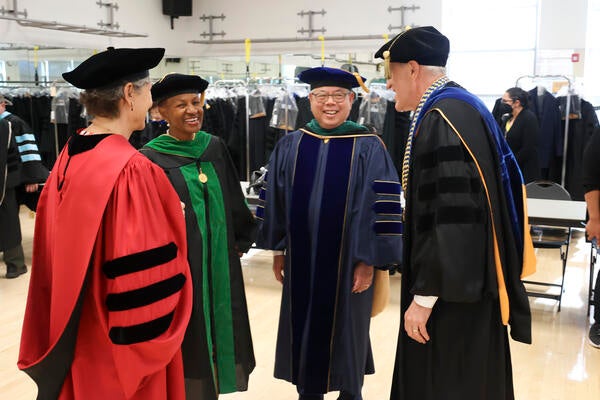 Peter Igarashi with Dean Deborah Deas, Provost Liz Watkins, and Chancellor Kim Wilcox at the 2023 commencement