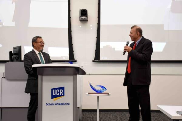 Dr. Thomas Haider presenting Dr. Lo with a plaque at the 2025 Haider Lecture