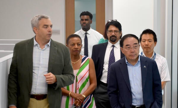 Vladimir Oge walking with Chancellor Hu and other senior leaders