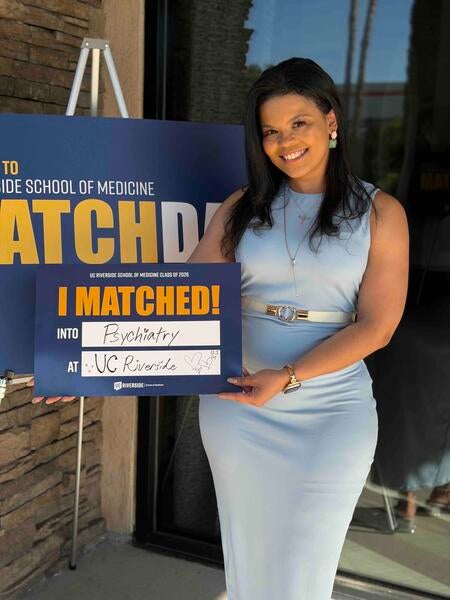 Charity Hall holding an "I matched!" sign