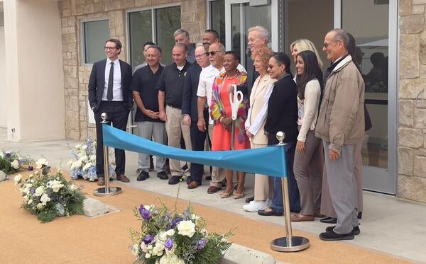 Dean Deas, Tim Collins, and Lisa Fortuna stand during the ribbon cutting.