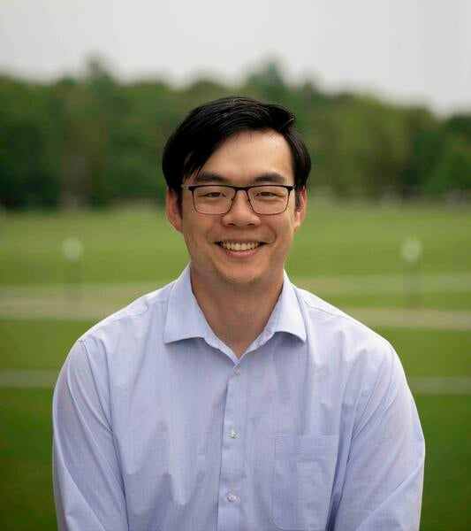 Andrew Huang in front of grass and trees