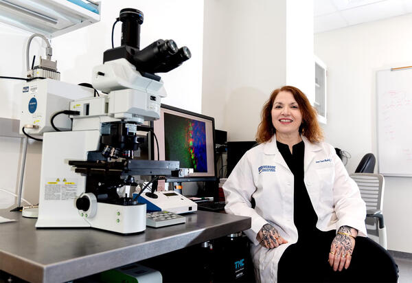 Seema Tiwarii Woodruff in front of a microscope