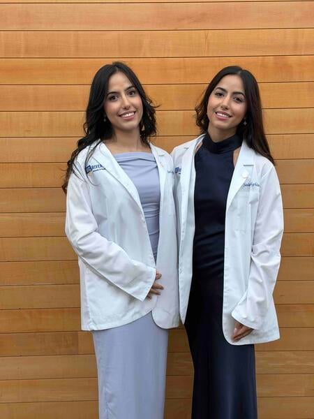 Assal and Sadaf Sadighian standing next to each other wearing white coats