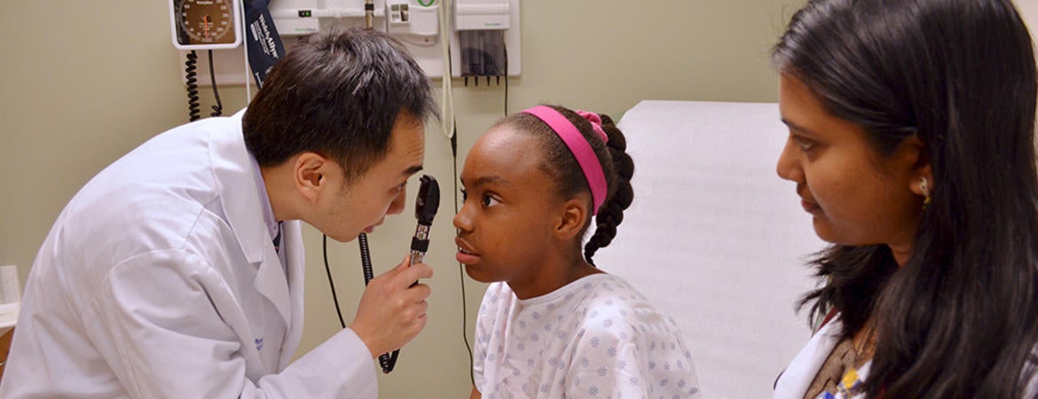 Medical student looking at a child in the eye