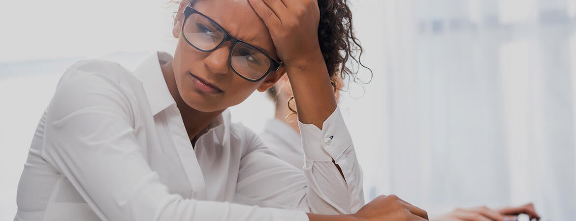 student looking stressed while sitting at a desk - photo courtesy of DepositPhotos.com