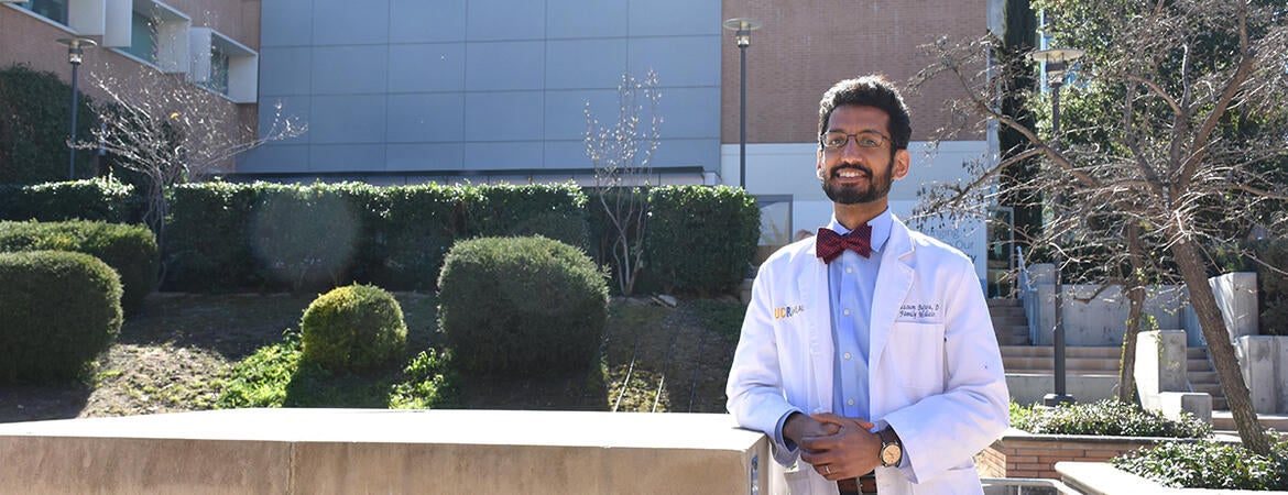 Moazzum Bajwa in front of the SOM Education Building