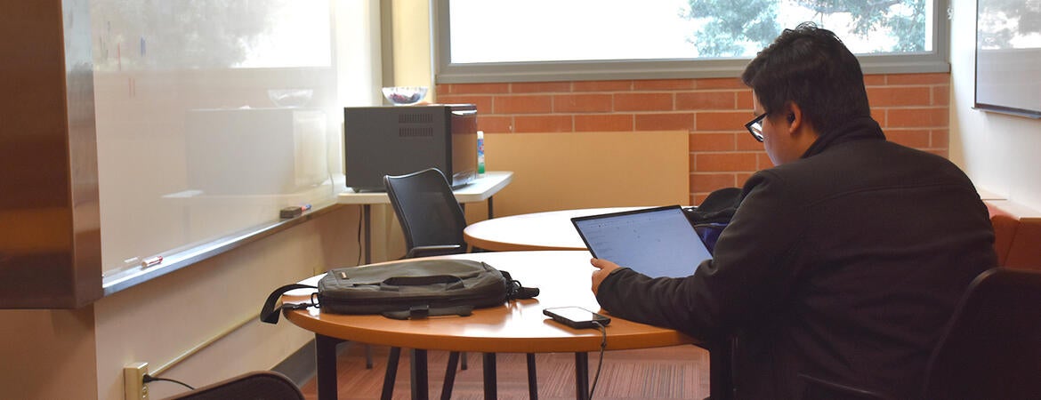 A UCR Medical Student uses his laptop in a student lounge.