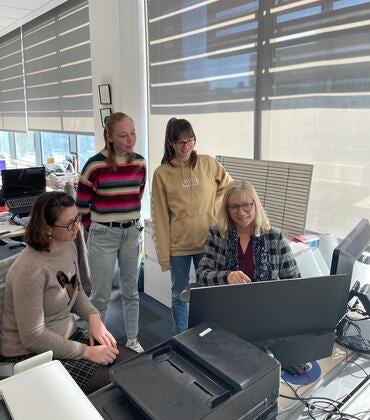 Dr. Iryna Ethell sitting at a computer surrounded by students