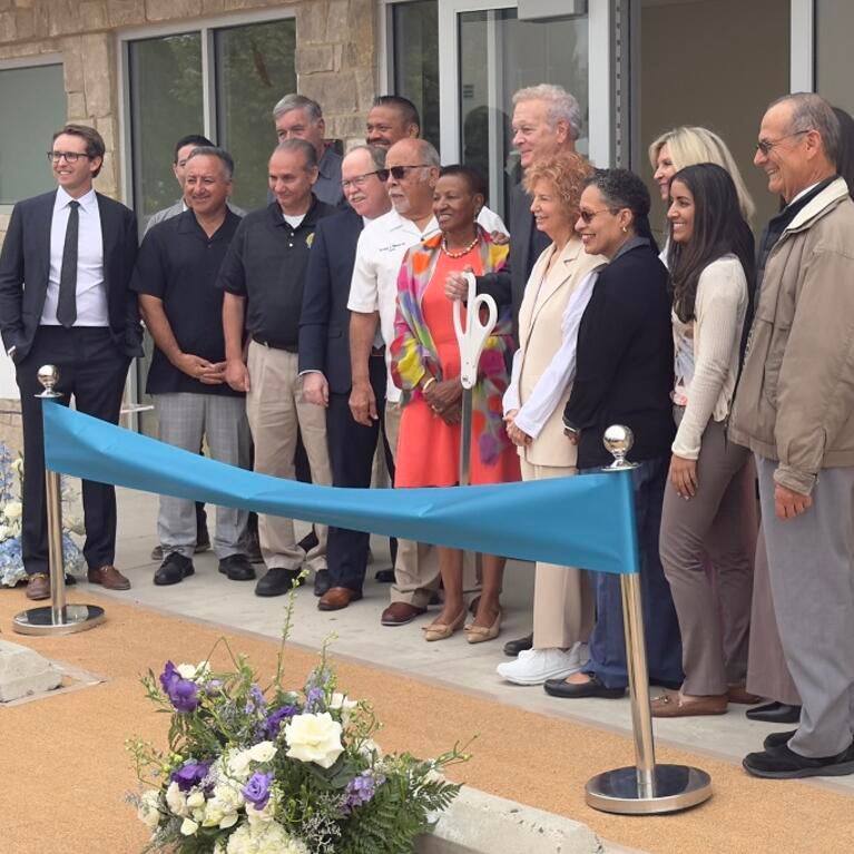 Dean Deas, Tim Collins, and Lisa Fortuna stand during the ribbon cutting.