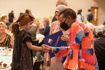 Dean Deborah Deas greets the daughter of a medical student