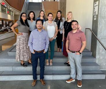 The Office of Academic Affairs team standing on the stairs in the SOM