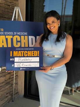 Charity Hall holding an "I matched!" sign