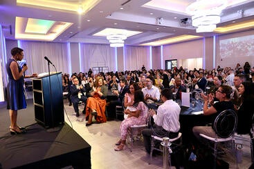 Dean Deas speaks to a full room of guests