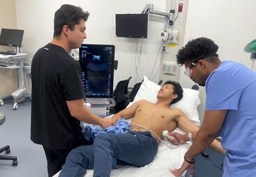 Two students doing ultrasound on a third student
