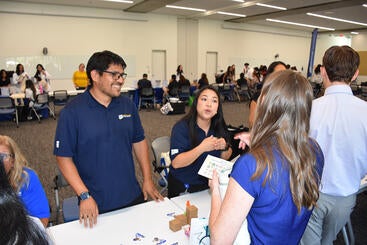 Darnell Sy, right, speaks to students as Humberto Santiago looks on.
