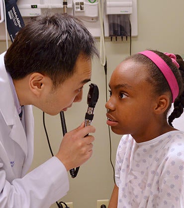 Medical student looking at a child in the eye